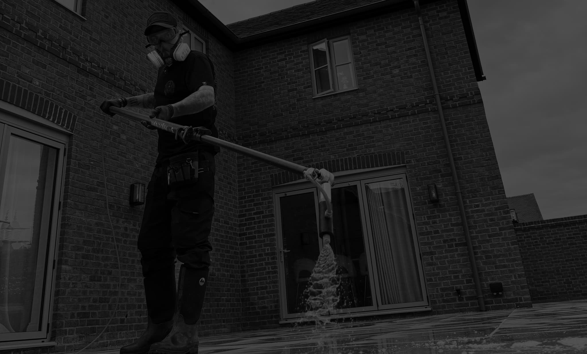 Chiltern Surface Co operative applying a low-pressure soft wash solution to the exterior of a brick house