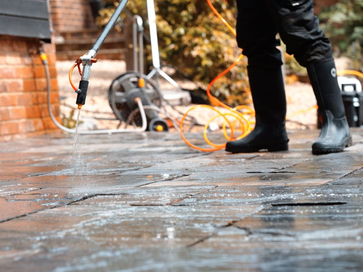 Chiltern Surface Co operative applying a specialist treatment to a natural stone patio with a low-pressure lance